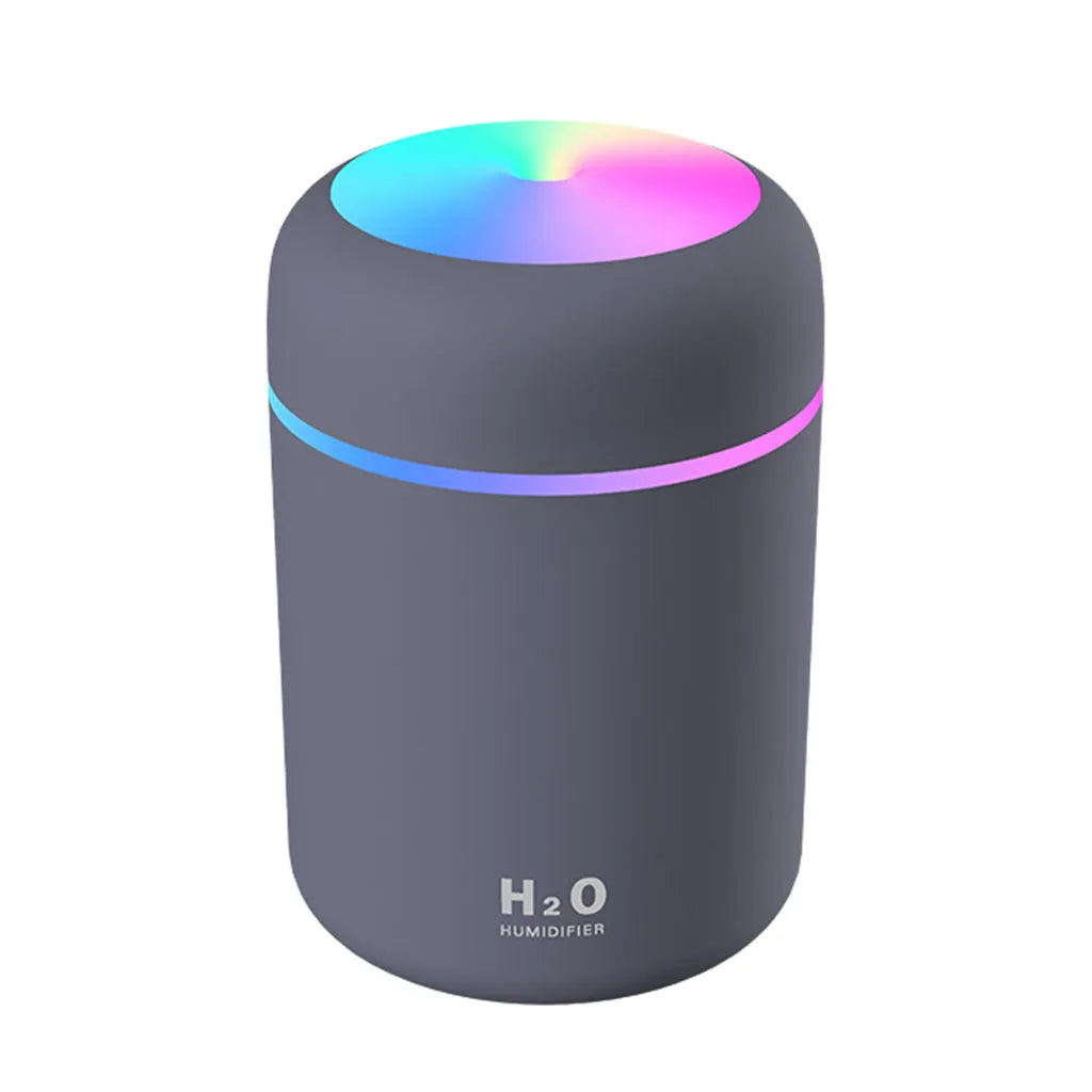 Mini ultrasonic essential oil diffuser with 300ml water tank in white, showing coloured night lights and USB cable