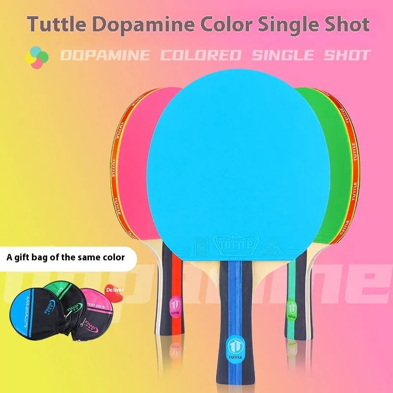 Blue, green, and pink professional table tennis rackets with long shakehand handles and matching carry bags.