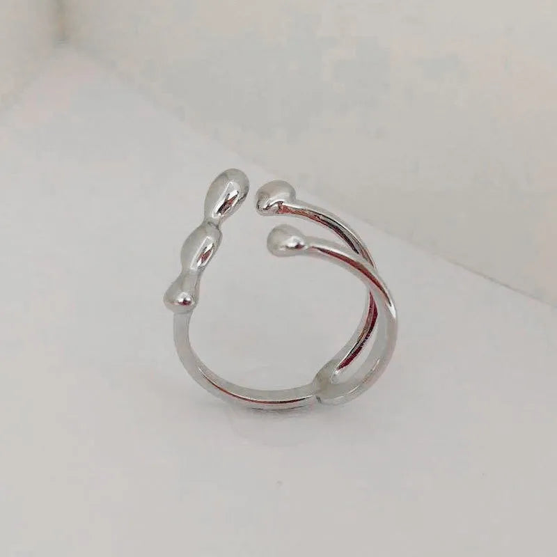 Gold and silver adjustable opening fashion ring with spherical design on a brass base.