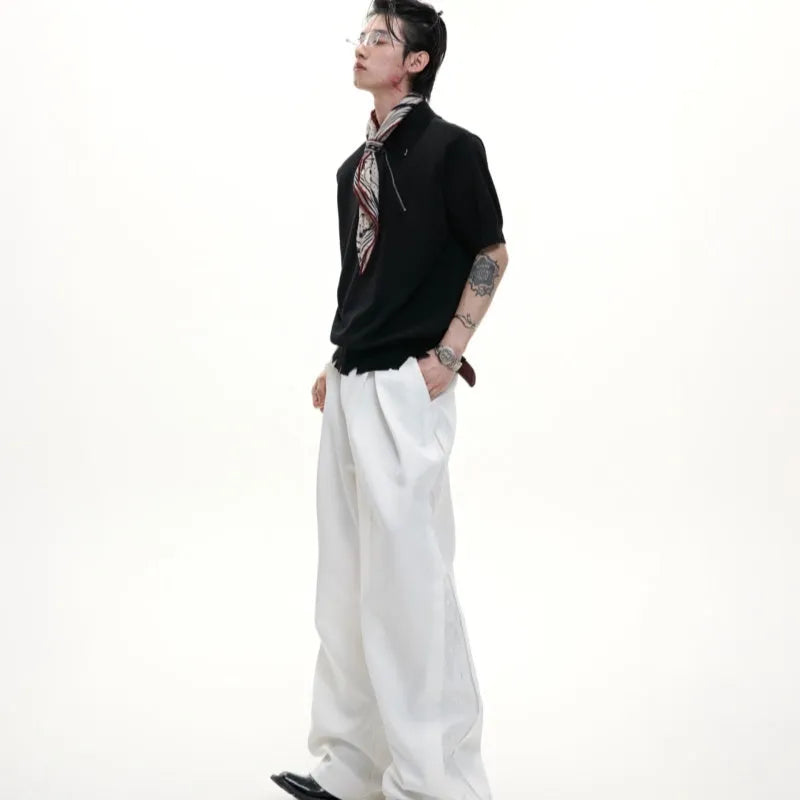 Man modelling a black slim-fit knitted polo shirt with a diagonal chest zipper and lapel collar.