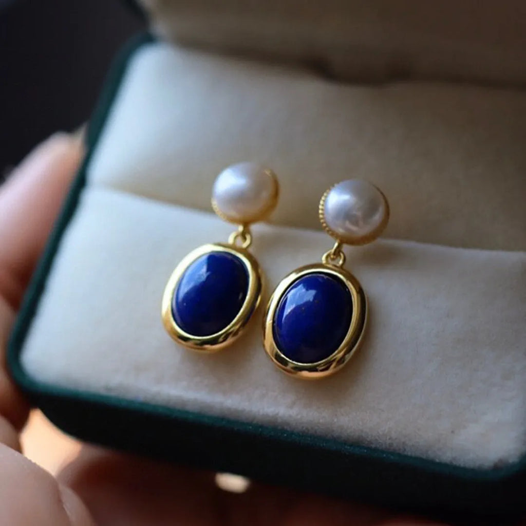 A pair of simple sterling silver drop earrings with blue lapis lazuli pearls and an auspicious pattern.