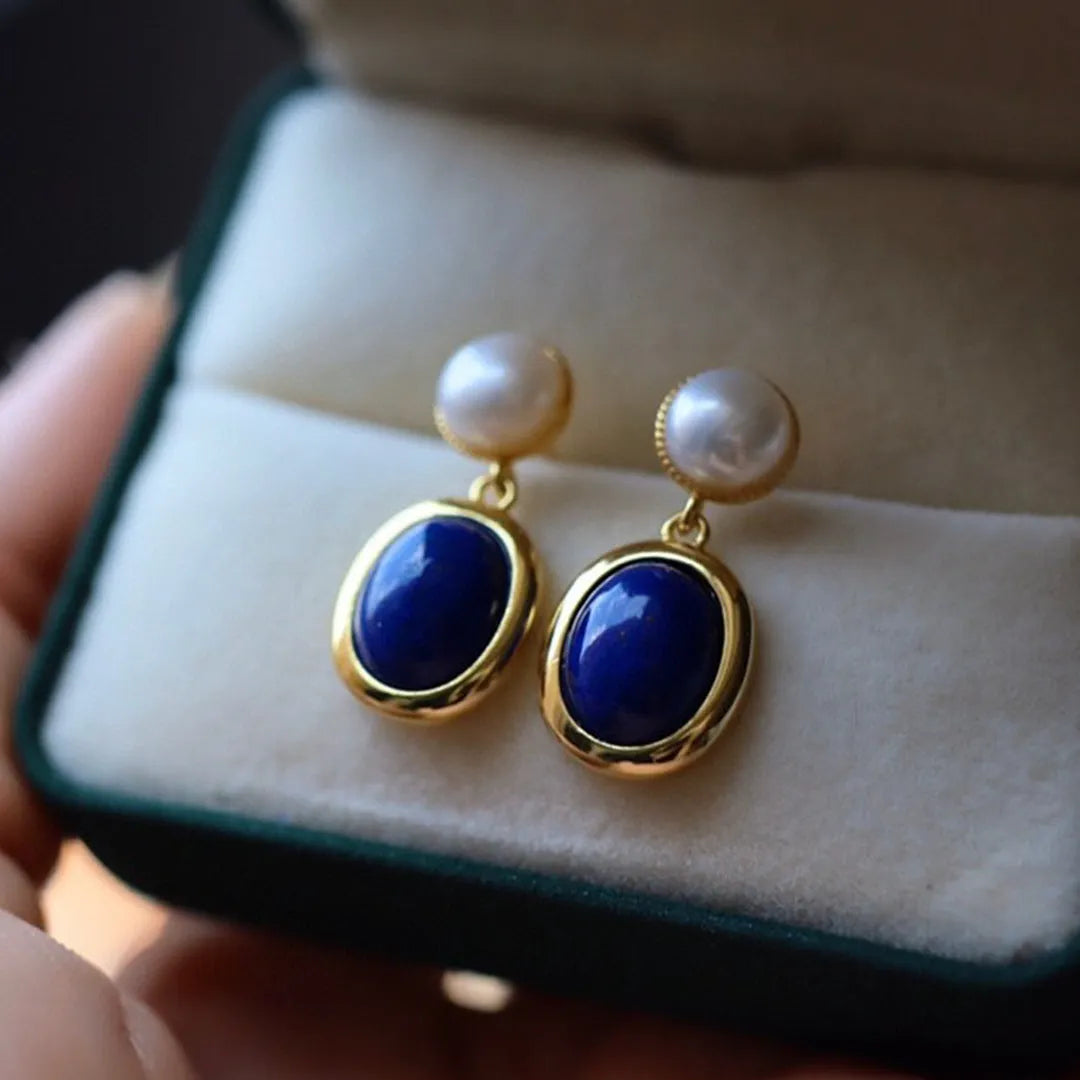 A pair of simple sterling silver drop earrings with blue lapis lazuli pearls and an auspicious pattern.