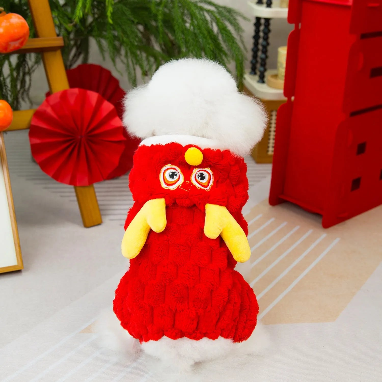 Red velvet pet jacket with cartoon dragon design for dogs and cats on a hanger