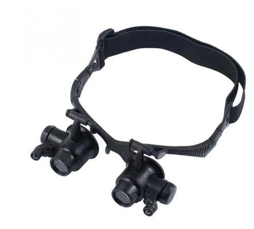 Black hands-free LED magnifying glasses with interchangeable lenses on a headband for watch repair.