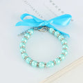 Small dog wearing blue imitation pearl necklace with rhinestones and ribbon bow adjustable collar