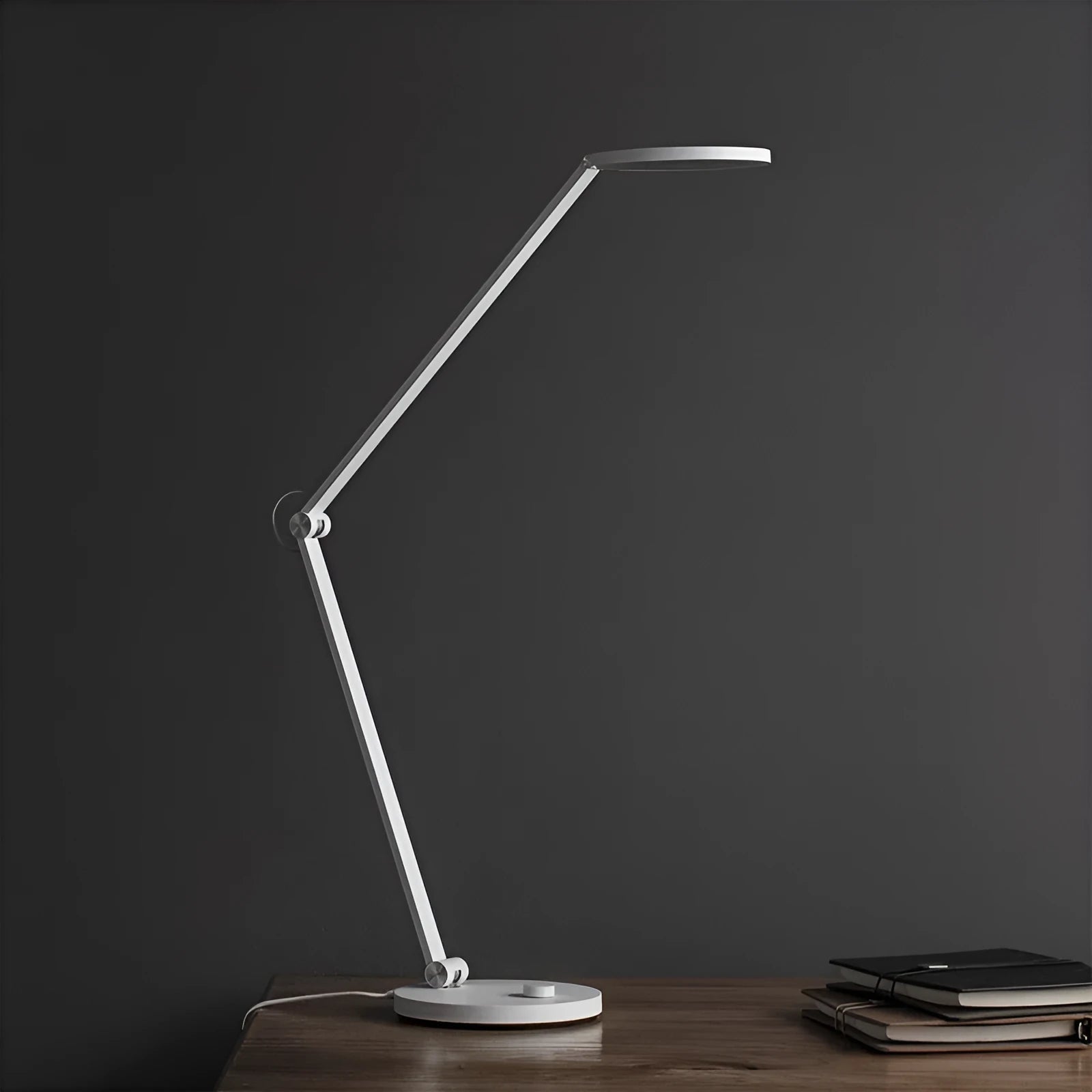 ProLED intelligent folding desk lamp with adjustable arm on a wooden desk.