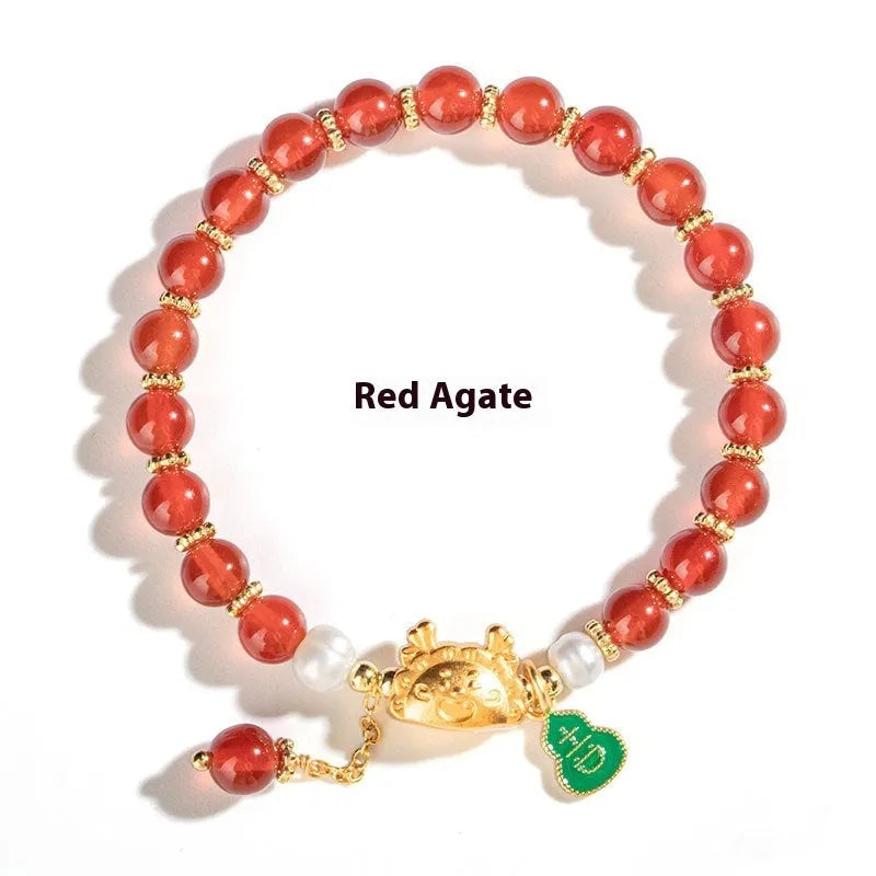 Natural agate bracelet with diamond-shaped beads and a dragon zodiac charm on a wrist.