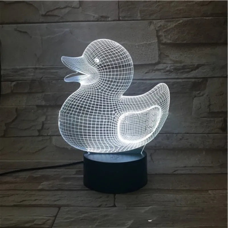 Little yellow duck 3D night light with remote control on a table, showing its colourful LED illumination.