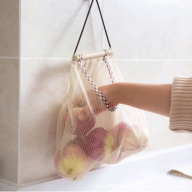 Beige plaid polyester mesh storage bag with cotton rope hanging loop on a white wall