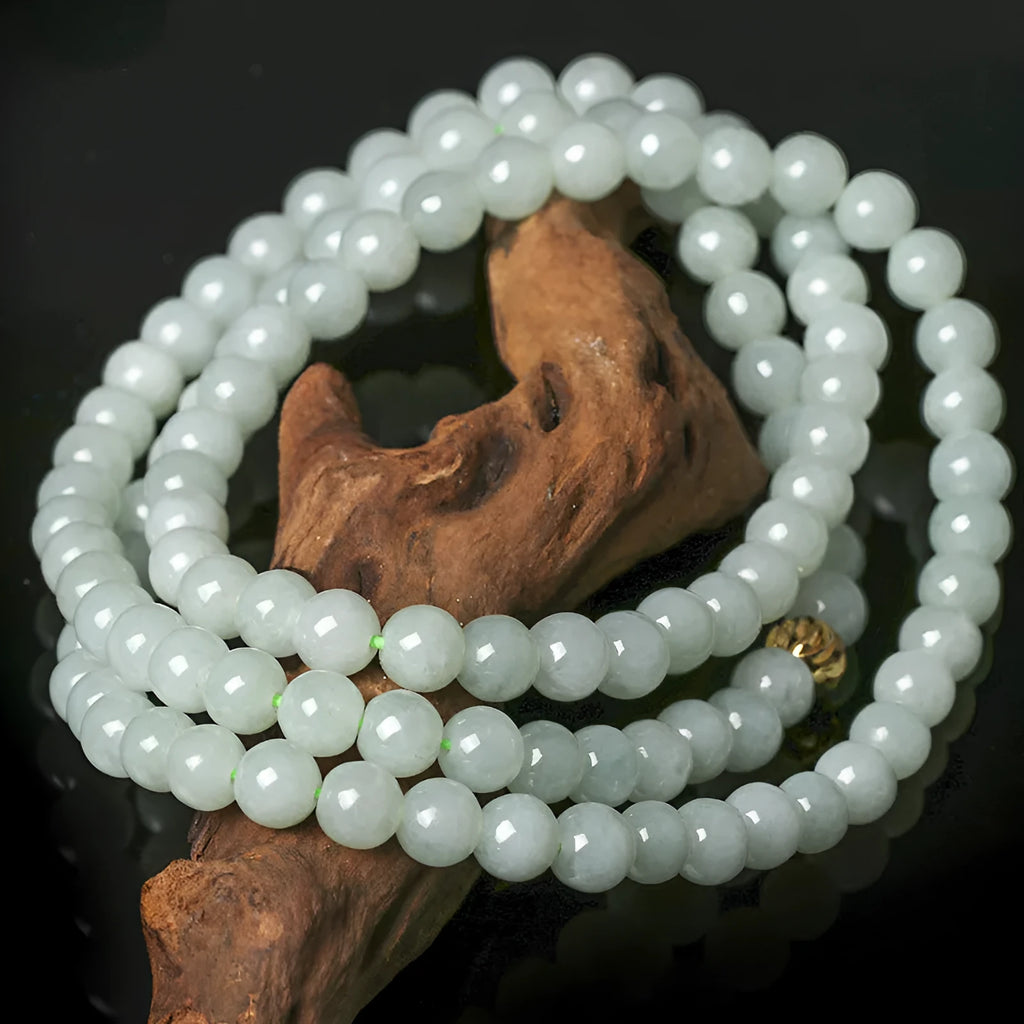 Natural white-green jade bead necklace with adjustable chain and 6.5mm round beads on grey background