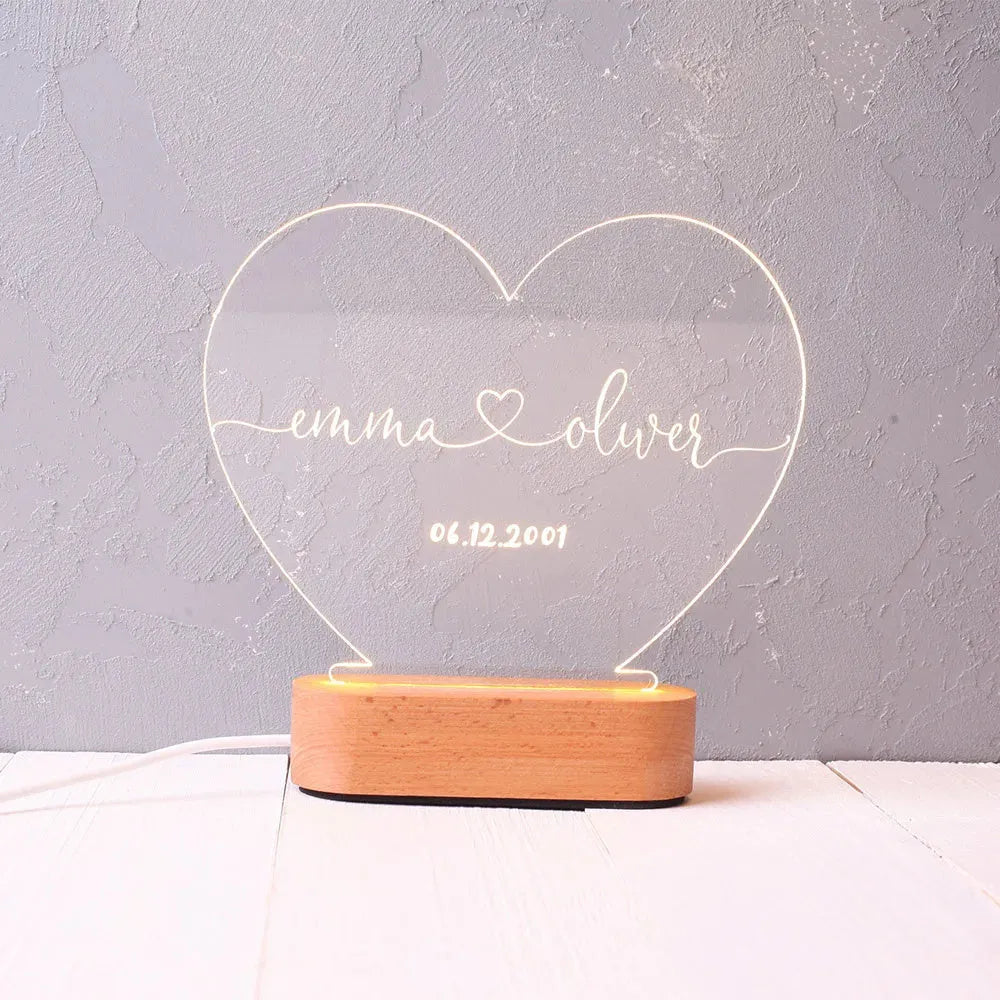 Custom transparent acrylic LED night light etched with personal names and date.