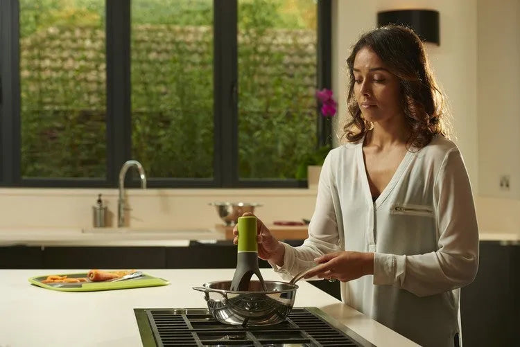Green or grey Uutensil Stirr automatic pot mixer device for hands-free stirring of sauces and soups.