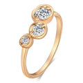 Three copper electroplated rings with lotus leaf design and round zircon stones in gold white zirconium tone on a flat surface