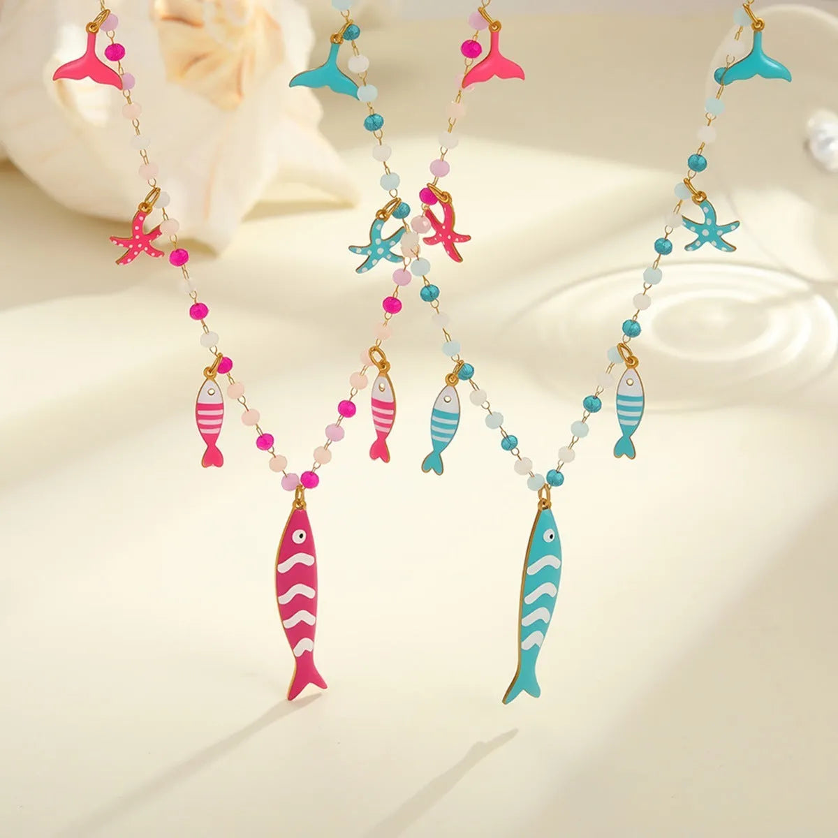 Stainless steel pendant necklace with oil drip beads, starfish design, 18K finish in pink colour, adjustable chain