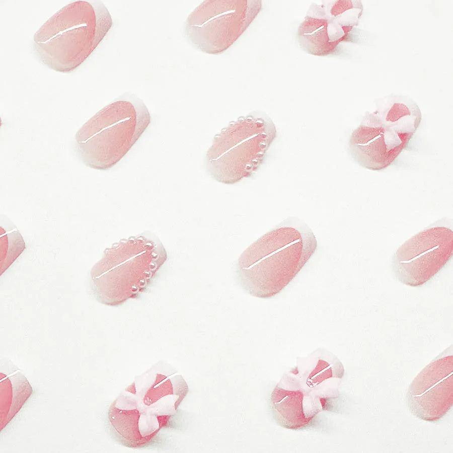 Pack of short white French manicure nail stickers with bow, tulip, and starry sky patterns.