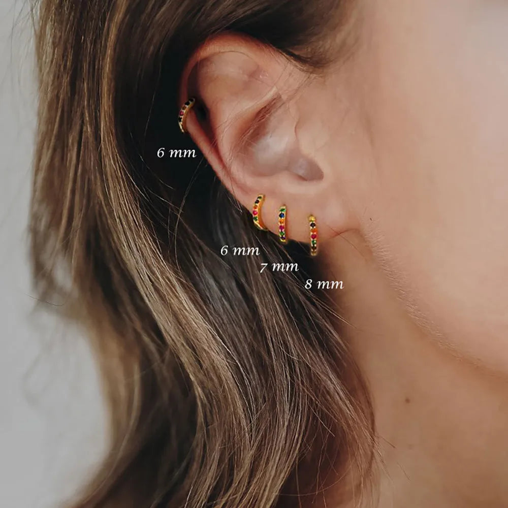 Geometric circle shape zircon perforated stud earrings in gold, rose gold, and silver colour on a white background.