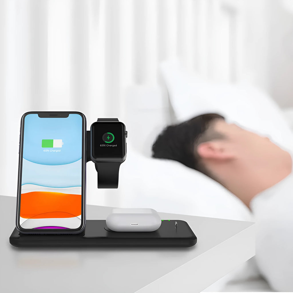 White three-device wireless charging stand on desktop with phone, watch, and headset charging simultaneously