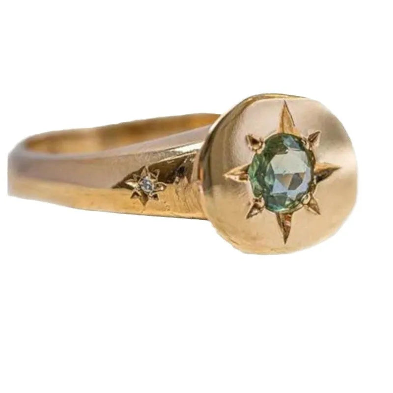 Gold-coloured star-shaped ring with a central oval zircon stone on an adjustable band.