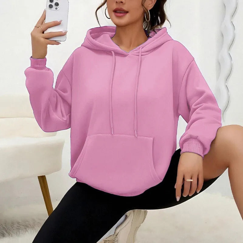 Women's loose fit grey sweatshirt with a drawstring pocket and long sleeves on a hanger.