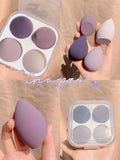 Four makeup sponge eggs in grape, mango, mint, and peach colours on white background
