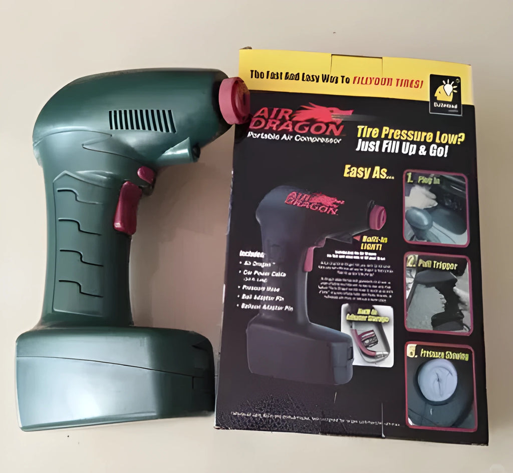 Compact black 12V portable car tyre pump with digital display, LED light, hose, and valve adapters on a grey background.
