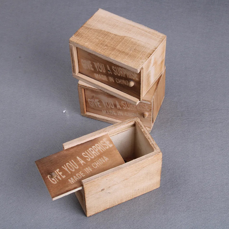 Wooden prank scare box open showing a lifelike spider figurine on a spring, next to the box lid.