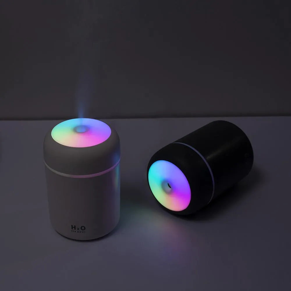 Pink, white, and navy blue USB-powered mini desktop humidifier with water tank and mist spray.