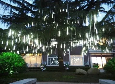 Waterproof LED meteor shower light set with 8 tubes in outdoor garden installation.