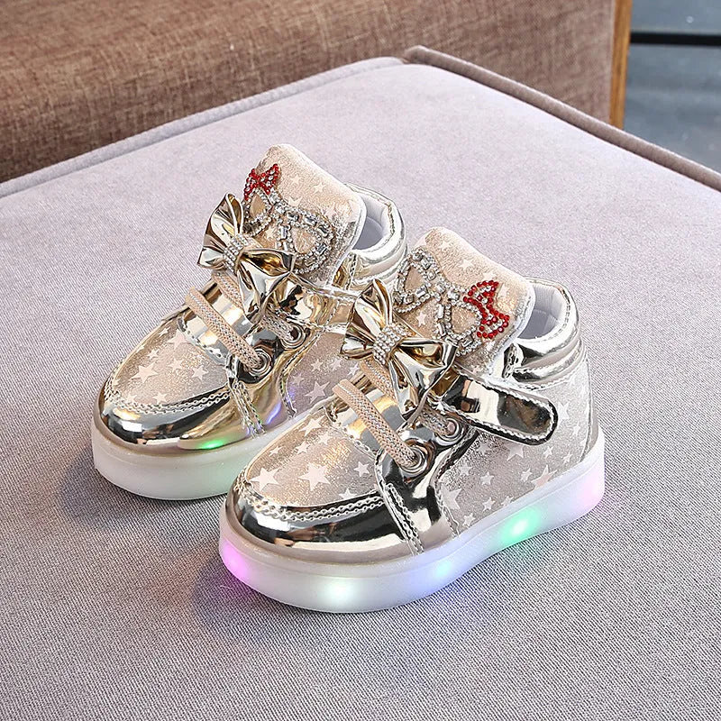 Golden children's LED sneakers with a light-up magic button on the heel