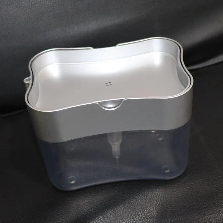 A grey plastic soap dispenser with a pump, sitting on a kitchen countertop.