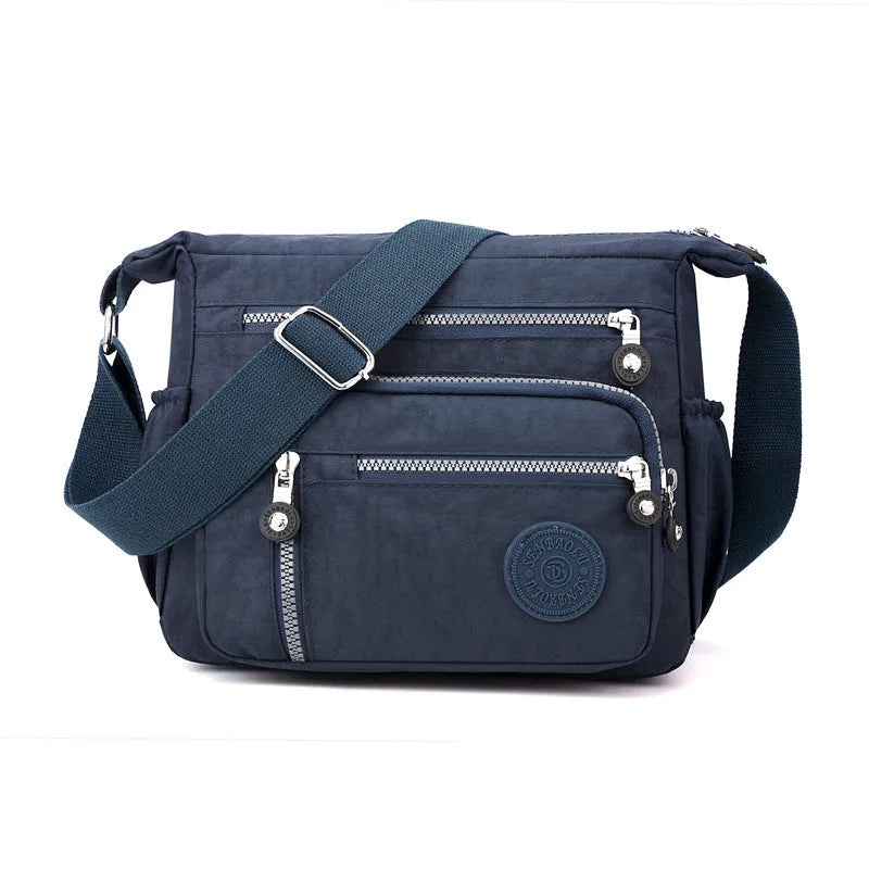 Soft grey nylon messenger bag with single shoulder strap showing square vertical shape