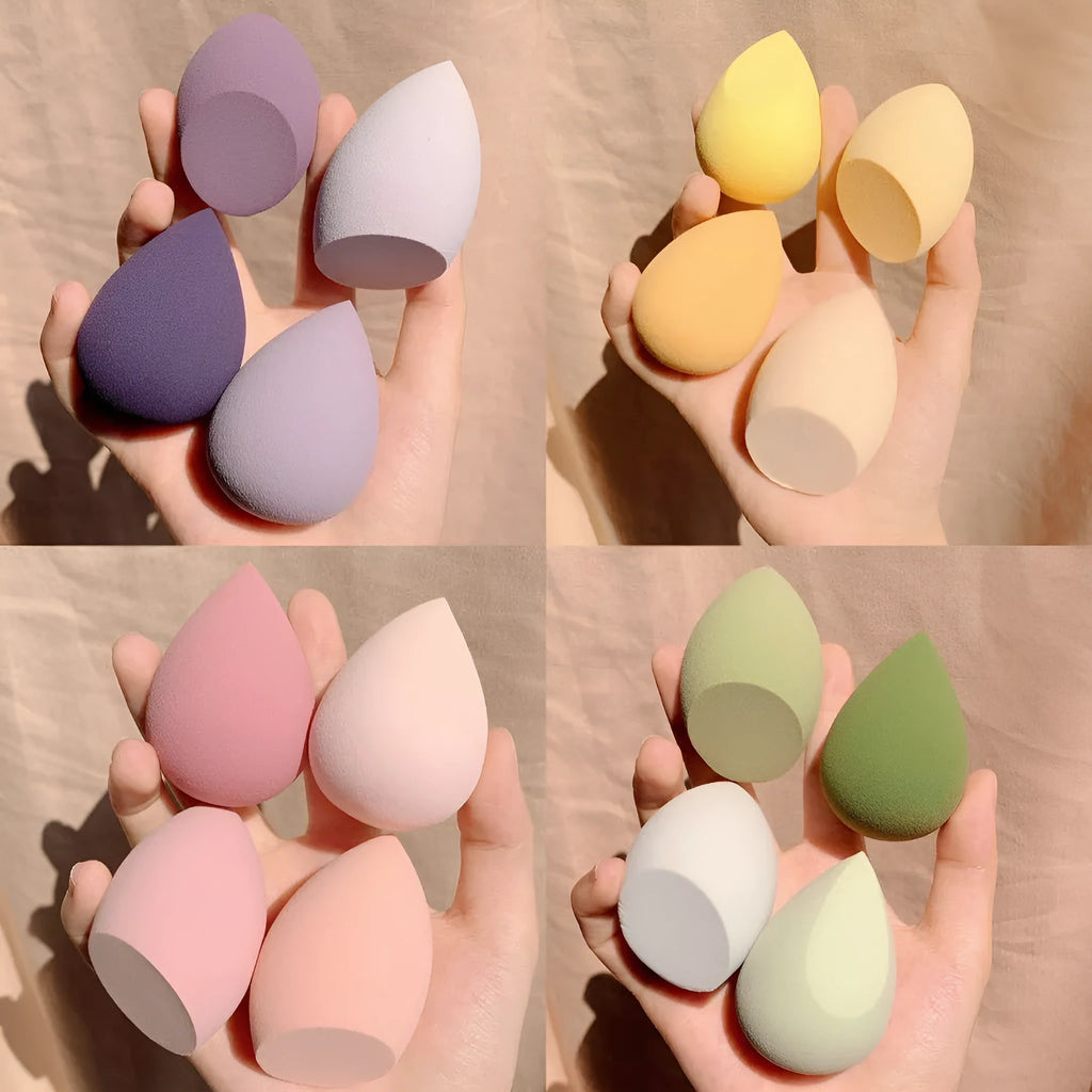 Four makeup sponge eggs in grape, mango, mint, and peach colours on white background