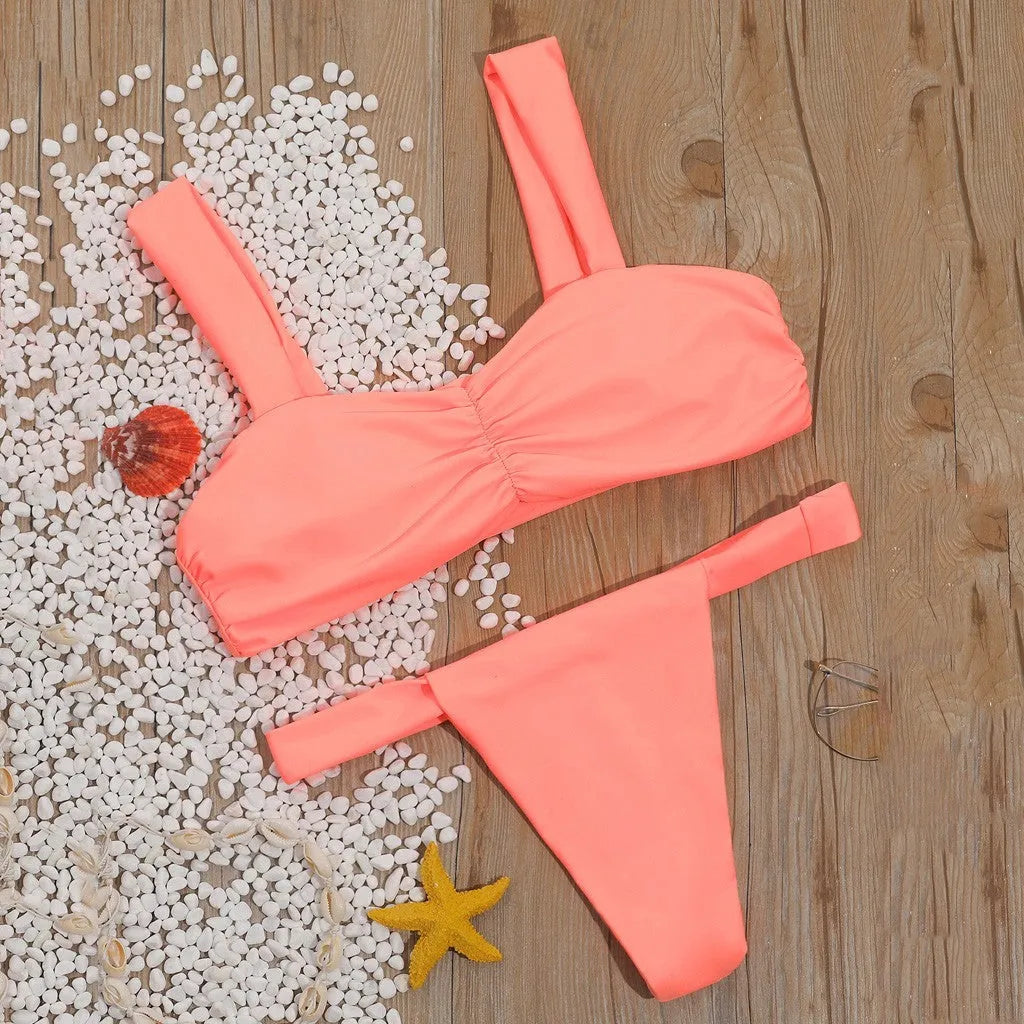 Solid colour split bikini swimsuit in orange on a model, showing two-piece design with nylon fabric
