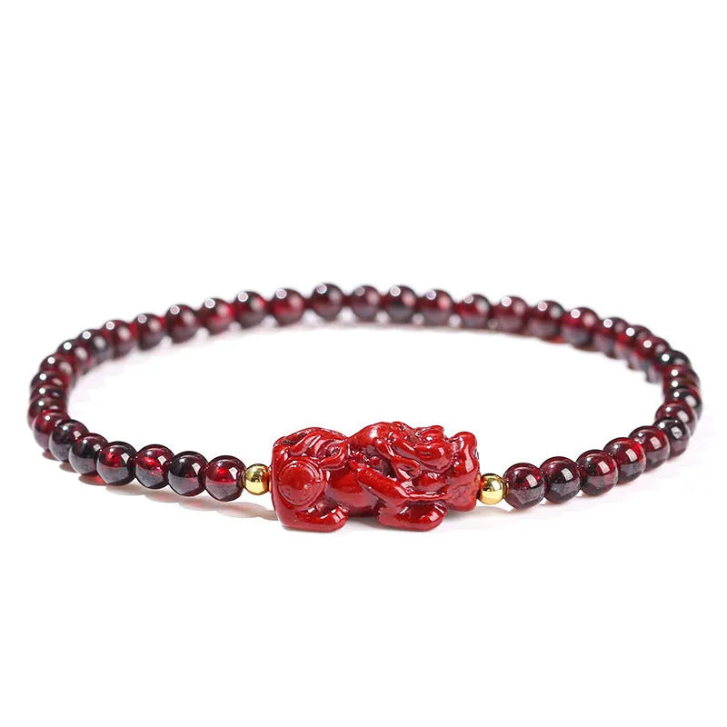 Geometric square garnet bracelet with carved Pixiu and strawberry quartz accents on a purple sand background.