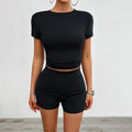 Women's solid colour slim-fit sports set with round-neck T-shirt and elastic shorts.