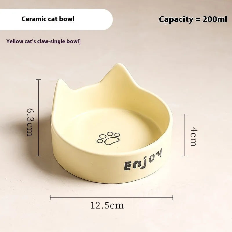 Porcelain cat bowl with cat ear handles in a wooden anti-tumble frame, showing paw print design.