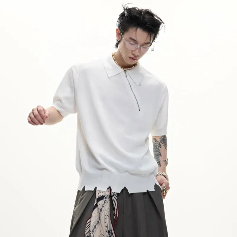 Man modelling a black slim-fit knitted polo shirt with a diagonal chest zipper and lapel collar.