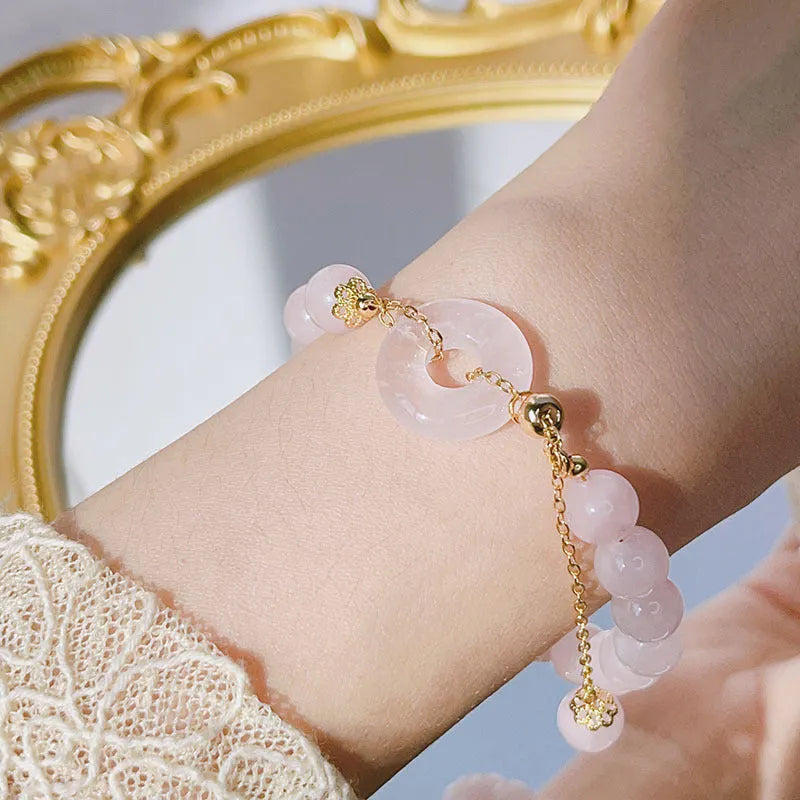 Pink crystal bracelet with peace symbol safety buckle clasp on woman's wrist