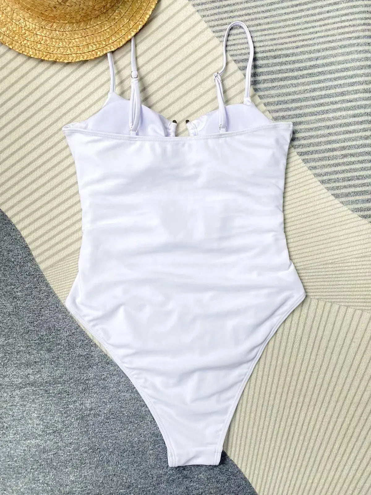Black women's one-piece swimsuit on hanger showing solid colour design and contemporary cut