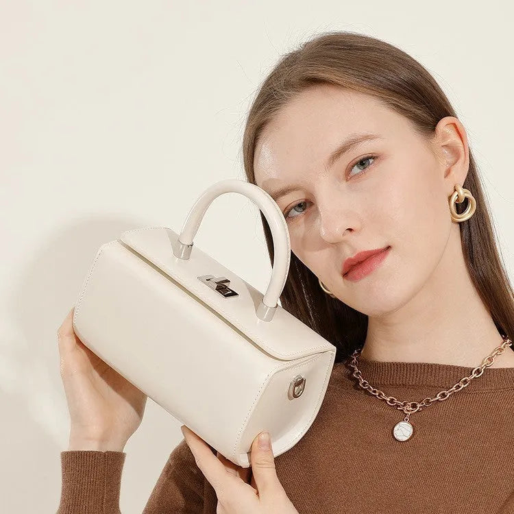 Structured leather women's crossbody bag in a clamshell design, shown in one of four colour options.