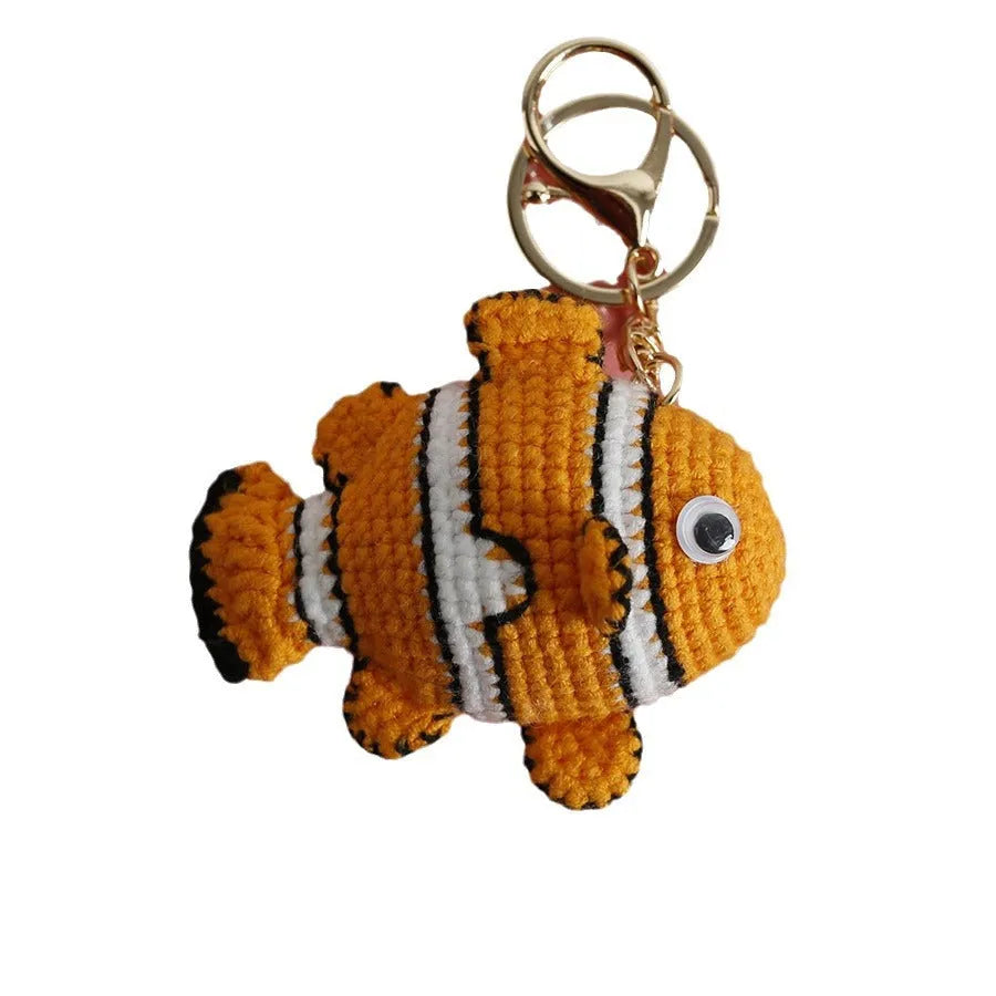 Crocheted wool fish keychain in cartoon ugly fish doll style with key ring, shown in orange, blue or pink