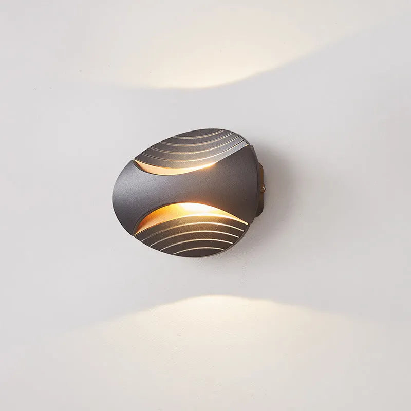 A modern aluminium wall lamp mounted beside a bed, showcasing its minimalist design.