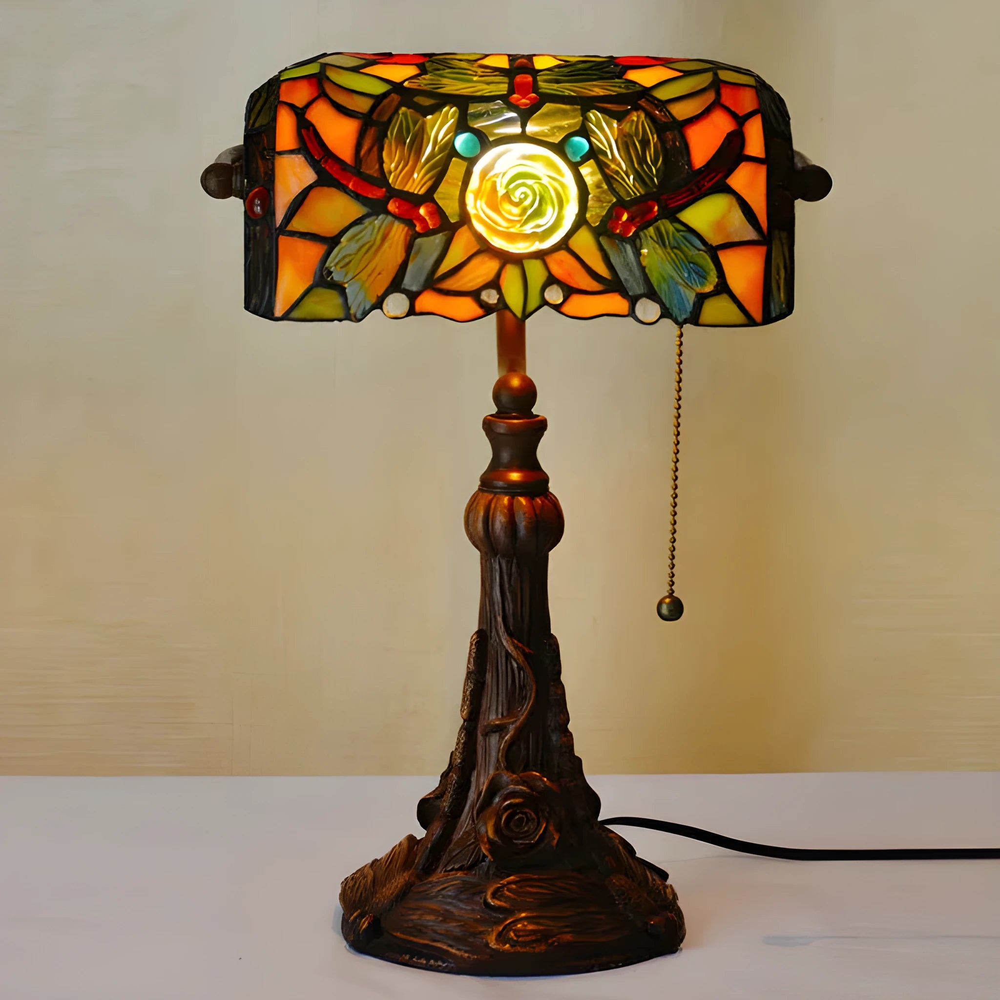 10-inch Tiffany style desk lamp with coloured stained glass shade and matching resin base on a wooden table.