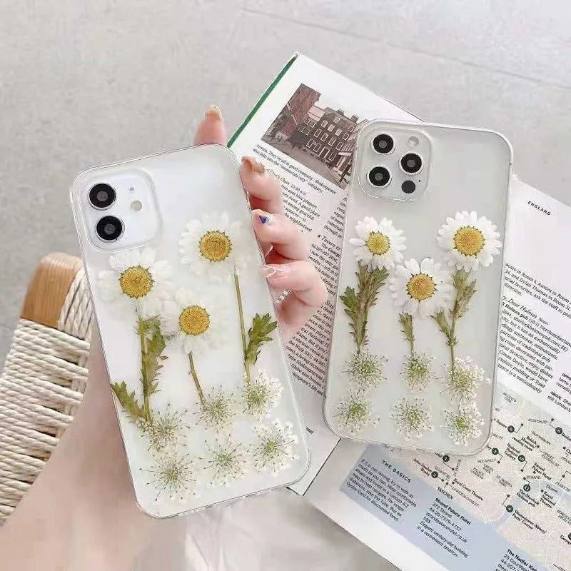 White TPU iPhone case with epoxy daisy floral design on back, shown fitted to a phone