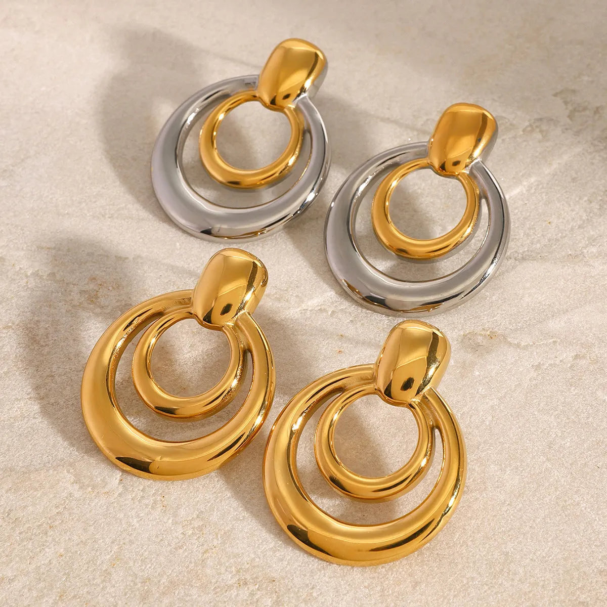 Gold-plated titanium steel hollow stud earrings with double-layer round geometry design