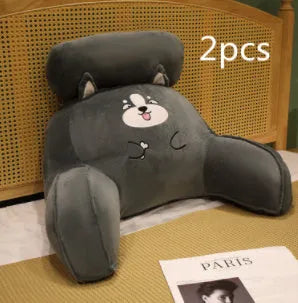 Large fluffy reading cushion with lumbar support in a dinosaur design on a sofa.