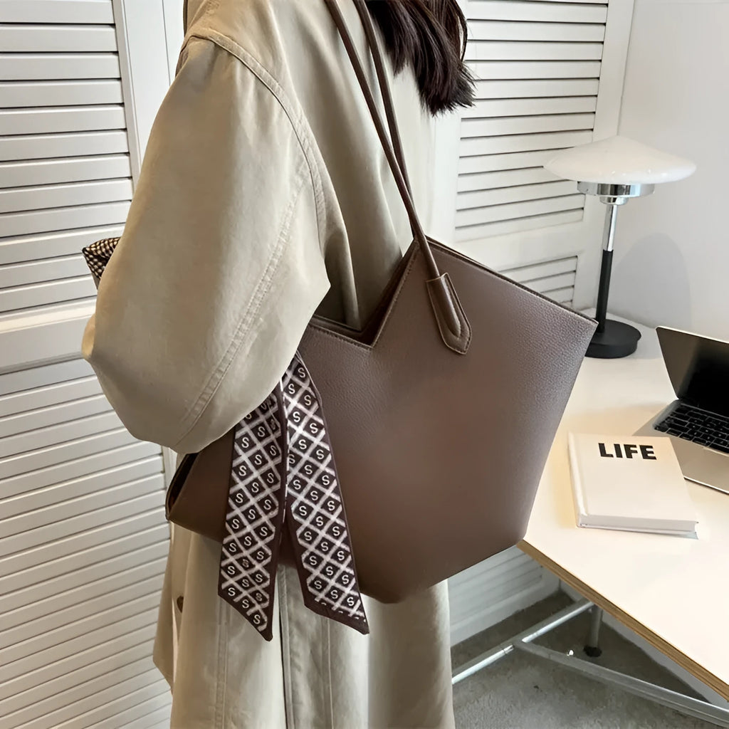 Women's large black PU shoulder bag with square shape and top handle on a neutral background