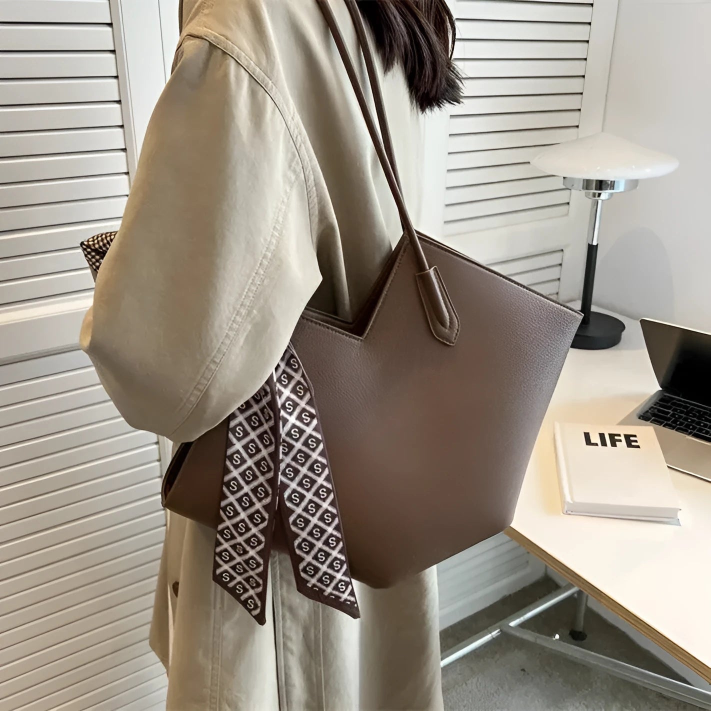 Women's large black PU shoulder bag with square shape and top handle on a neutral background