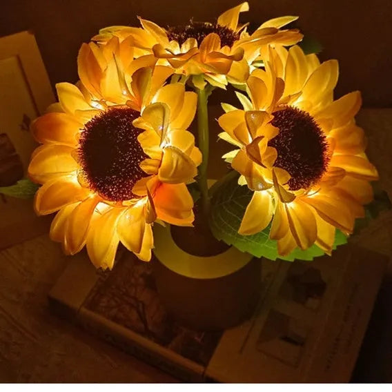 Rechargeable artificial sunflower LED night light on a table with USB cable.
