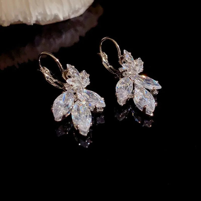 Platinum colour leaf-shaped earrings with zircon inlay creating shiny reflective surfaces